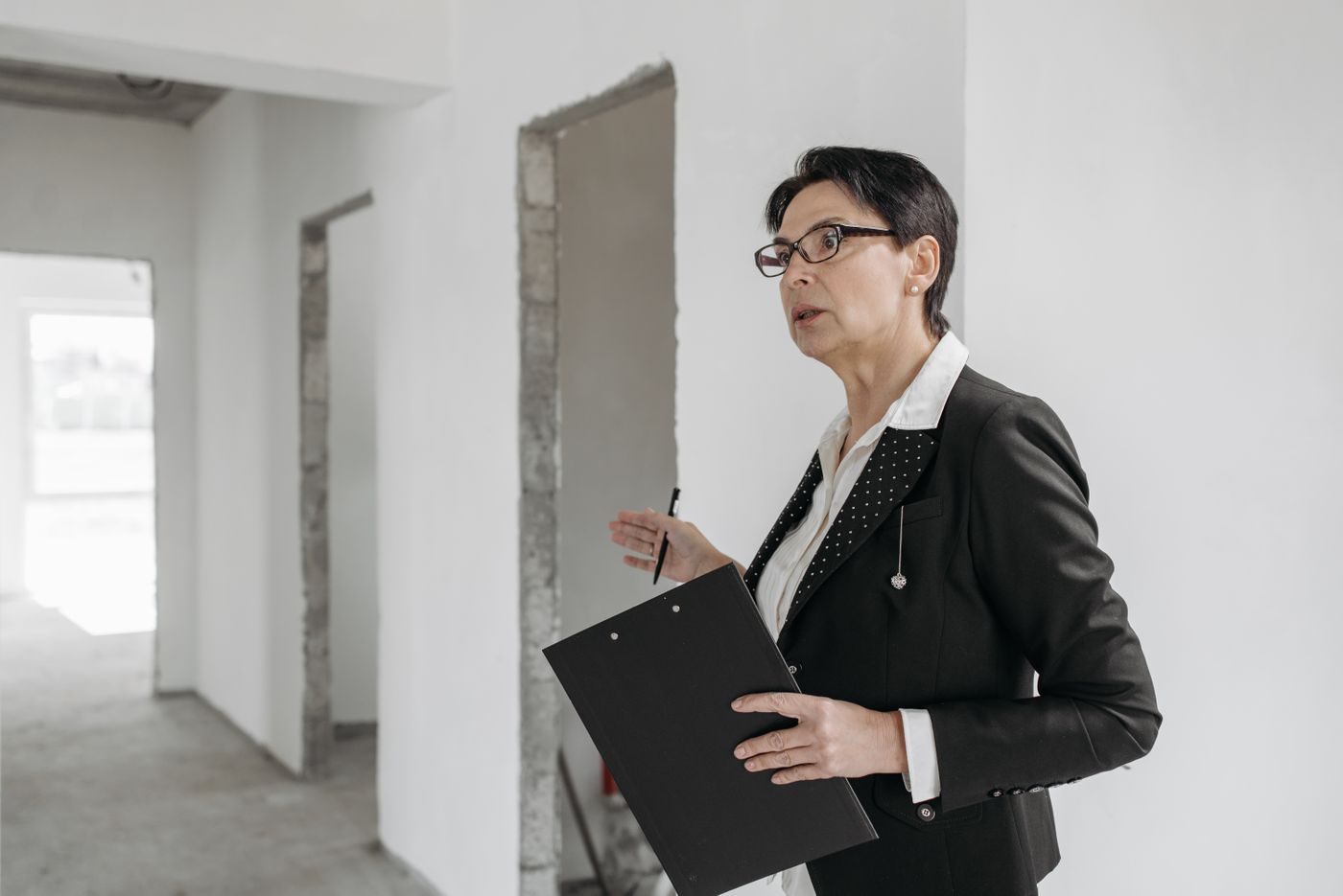 Inspector with a clipboard checking an empty flat